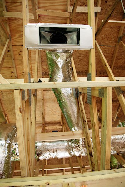 Вентиляционный диффузор и воздуховоды размещенные в потолочных балках при возведении каркасного дома с сауной.
