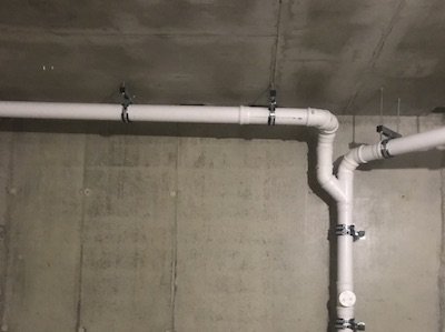 Монтаж трубопроводов бесшумной внутренней канализации в подвале здания.