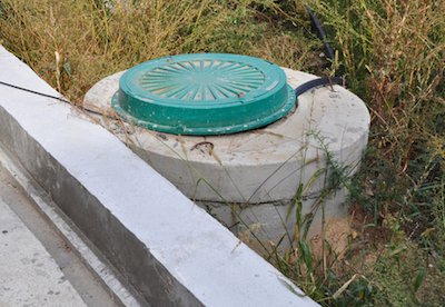 Пластиковый люк с обечайкой на самостоятельно изготовленном септике из бетонных колец